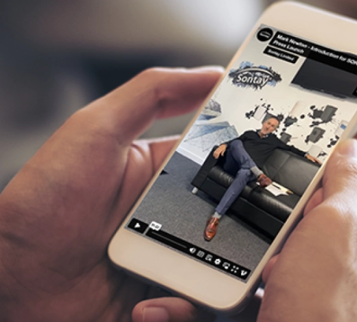 person holding a mobile phone that displays Sontay's SORA launch video